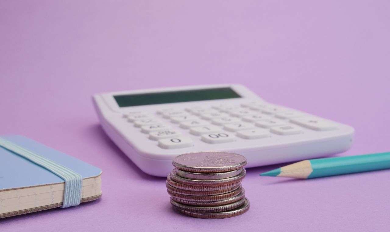 Calculatrice, pièces et carnet pour estimer le prix d'un cours